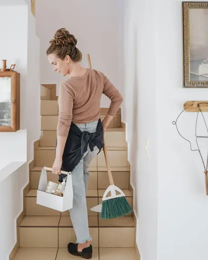 Städare på väg upp för trappan med städmaterial